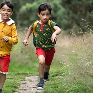 Little-Green-Radicals-Green-And-Yellow-Short-Sleeve-Henley-Top-With-Giraffe-Print-Kid-Running