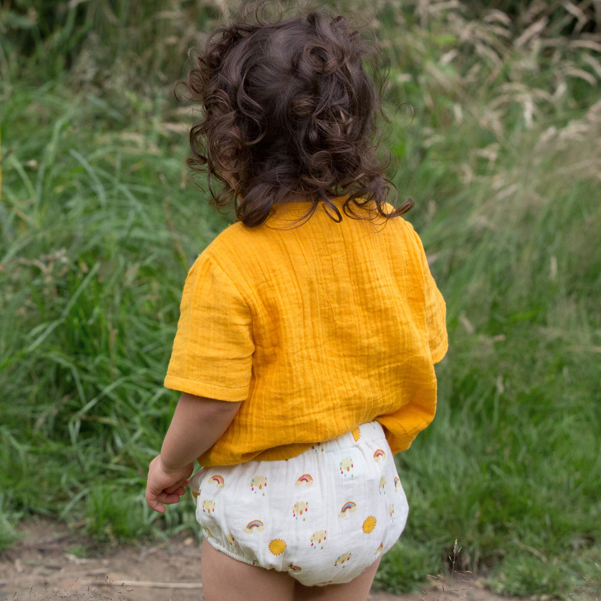 Little-Green-Radicals-Yellow-Organic-Muslin-Bloomer-Set-2-Pack-With-Sunshine-And-Rainbow-Print-Kid-Back