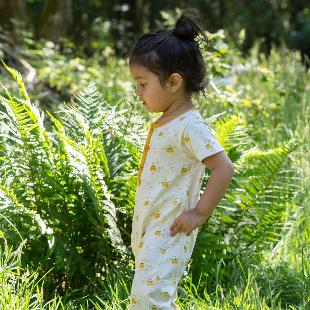 Little-Green-Radicals_Cream-and-Yellow-Organic-Shortie-Romper-With-Lemon-Grove-Print-Kid-Posing