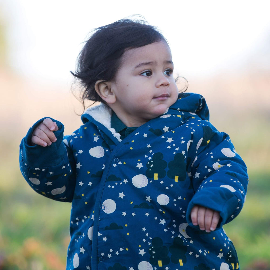 Close up model shot of dark blue baby snowsuiit with sherpa lining, moon and star print